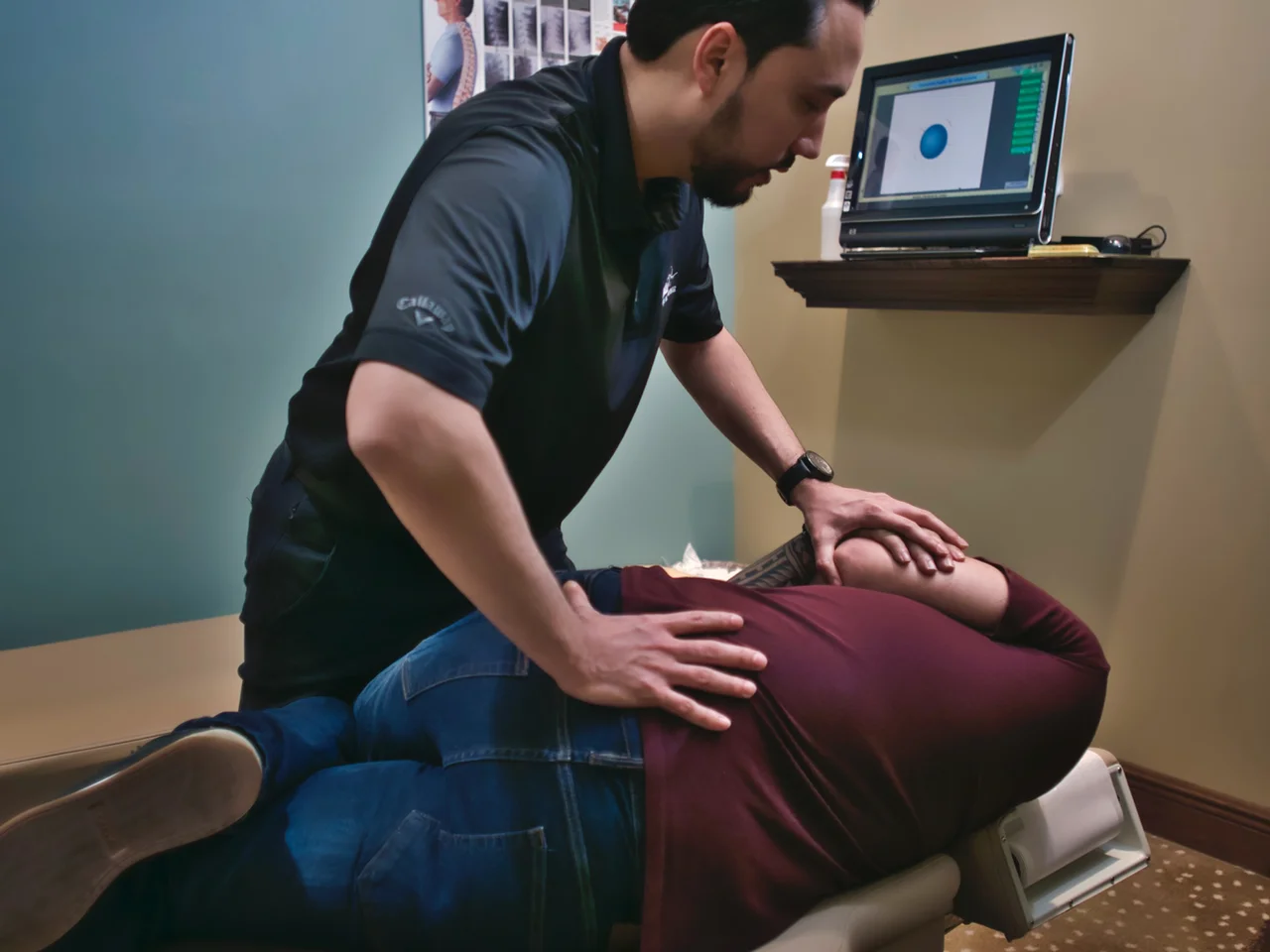 Chiropractor performing a spinal adjustment on a patient